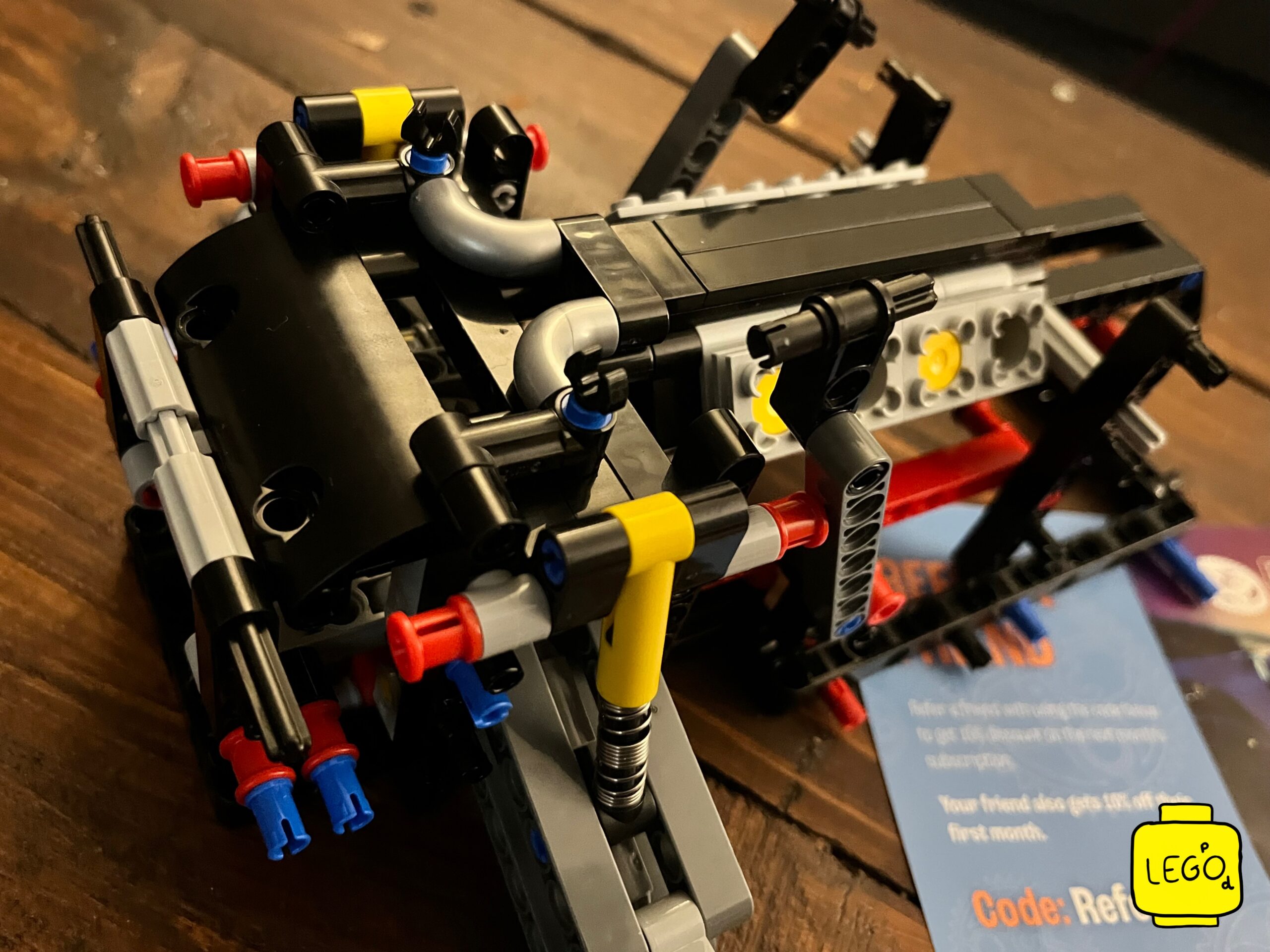 LEGO Technic 42111 Doms Dodge Charger V8 engine block sub-assembly with rubber hose details on wooden table