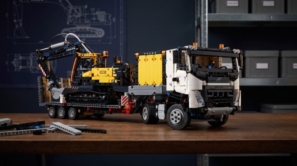 LEGO Technic Volvo FMX Truck and EC230 Electric Excavator (42175) on a workbench in a home workshop