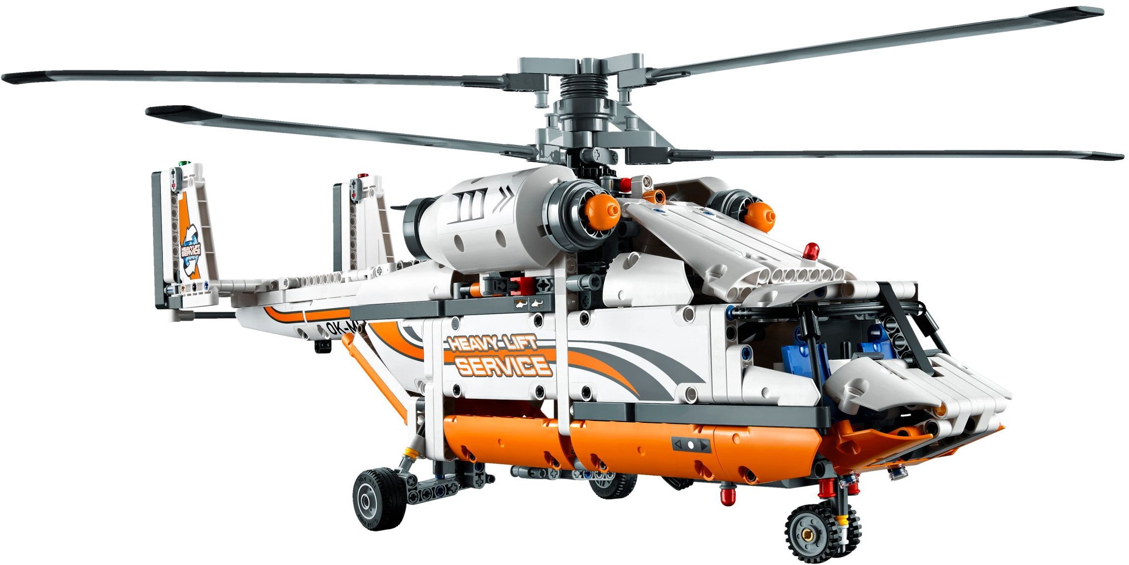 Left side view of LEGO Technic Heavy Lift Helicopter (42052) showing the two white turbine engine covers on the roof, the open cockpit with blue seats, the orange belly panels and the twin rudders at the tail
