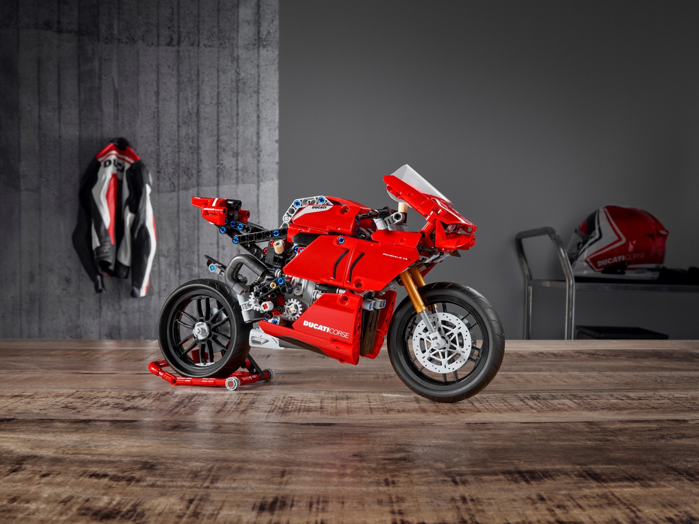Right side of LEGO Technic Ducati Panigale V4 R (42107) on its paddock stand, showing the exhaust pipe and the grey gears visible below the side panel