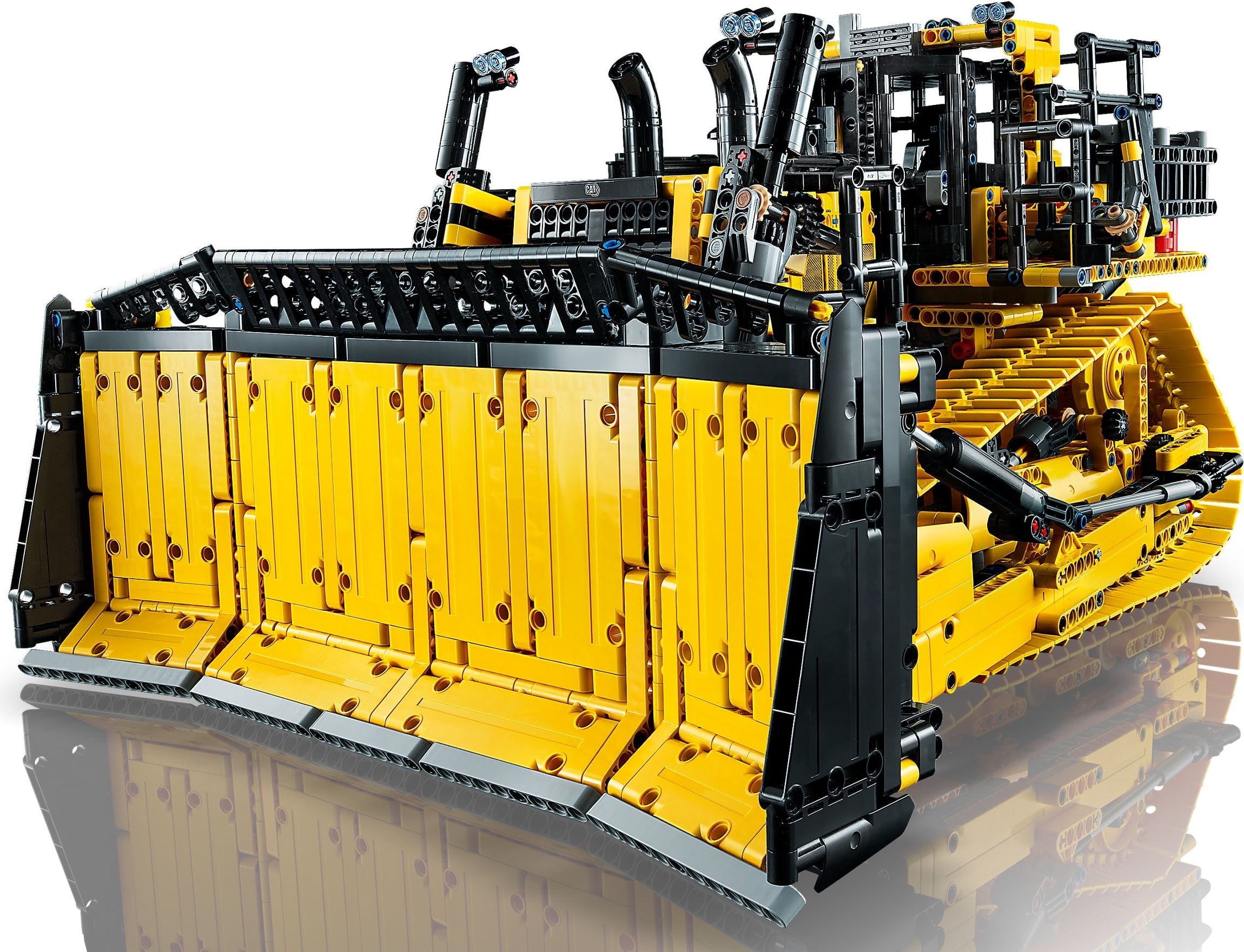 Front view of LEGO Technic Cat D11 Bulldozer (42131) showing the blade built from five yellow panel sections with a grey cutting edge, the black top rail and end plates, and a black linear actuator on the push arm behind it