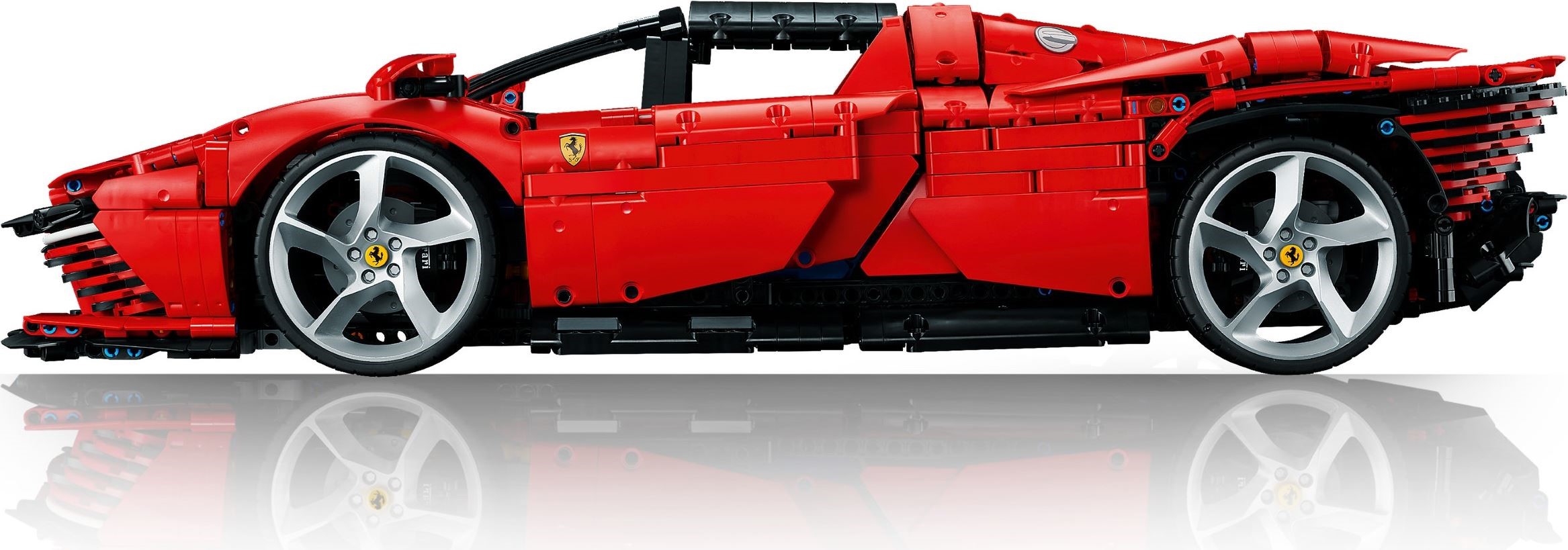 Side profile of LEGO Technic Ferrari Daytona SP3 (42143) showing the black roof bar, printed Ferrari shield on the door, printed fuel filler on top of the rear haunch, five-spoke silver rims and the slatted tail